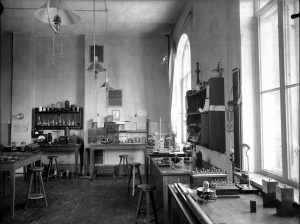 Interiør fra Den tekniske skole i Munkegaten 1. Bildet viser et klassserom med benker, bord, en tavle, undervisningsmateriell. Yrkesskole. 1898 - 1910. Foto: Erik Olsen/NTNU UB Lisens: CC BY-SA 4.0 ID: O-I-1968_01